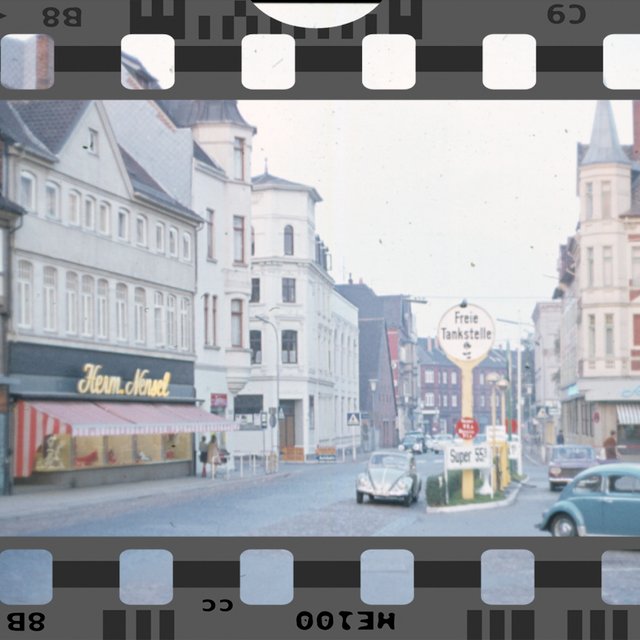 Das Bild zeigt eine historische Aufnahme vom Historischen Marktplatz in Peine, als sich dort noch eine Tankstelle befand und Autos in der Innenstadt fahren durften. 