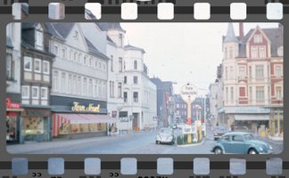 Das Bild zeigt eine historische Aufnahme vom Historischen Marktplatz in Peine, als sich dort noch eine Tankstelle befand und Autos in der Innenstadt fahren durften. 